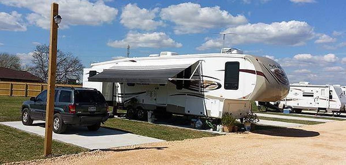Fifth-wheel RV with awning at Freeport RV Park campsite